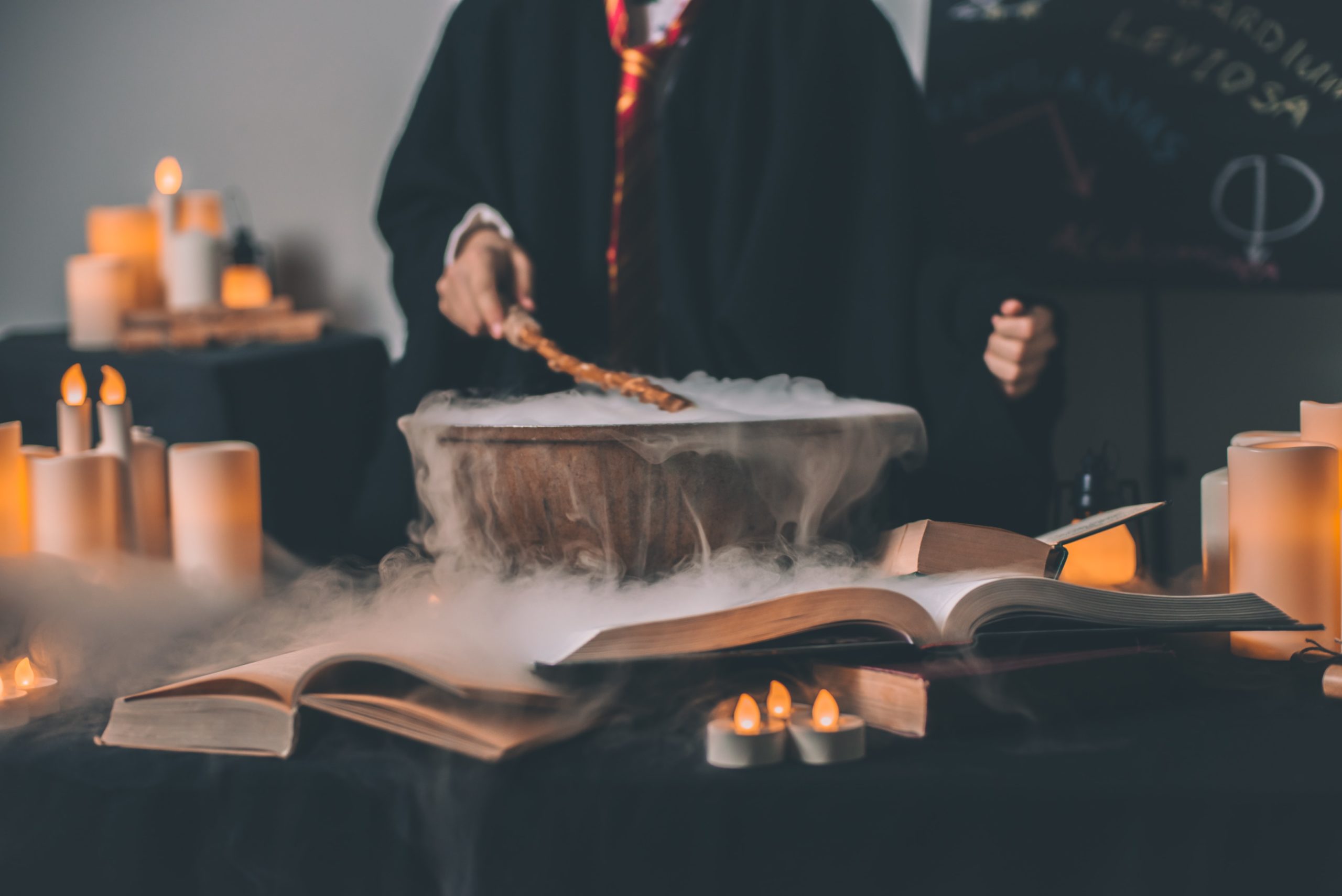 Children dressed in robes work as a team to cast spell with wand